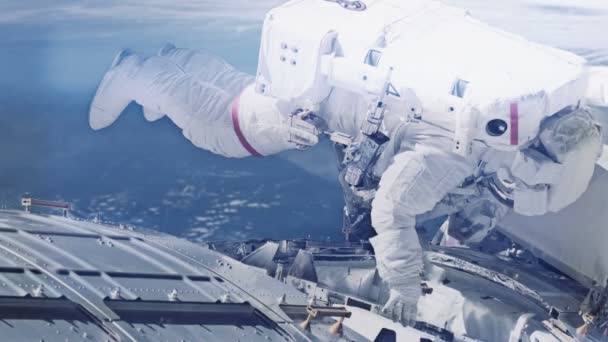Astronauta haciendo reparaciones en la estación espacial — Vídeo de stock