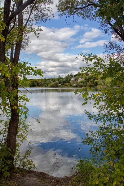 Järvi heijastus pörröinen pilvet — kuvapankkivalokuva