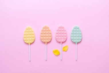 Minimalizm, pembe arka planda çikolatalı pop konsepti. Düz yatıyordu. Boşluğu kopyala.