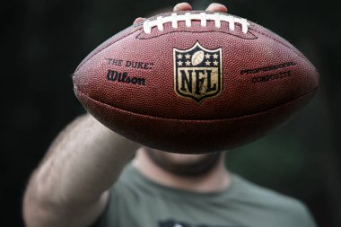  Profesyonel bir atlet Amerikan futbolu için top tutuyor..