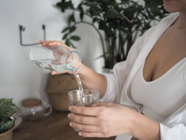 Genç kadın beslenme uzmanı. Sağlıklı yiyecekler, sağlıklı yiyecekler, yemek hazırlayan kadınlar. Su içen genç bir kadın