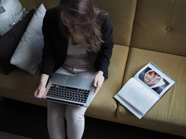 Evden bilgisayarla çalışan genç bir kadın, uzaktan kumanda.