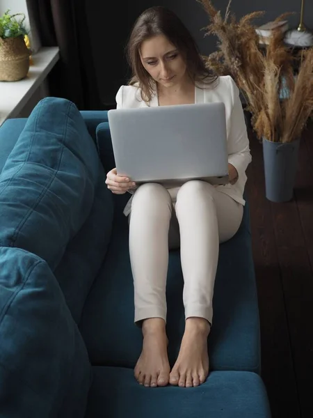 Evden bilgisayarla çalışan genç bir kadın, uzaktan kumanda.