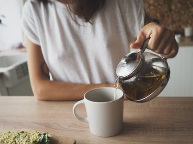 Genç kadın yemek hazırlıyor, çay yapıyor, meyve püresi yapıyor ve yiyor.