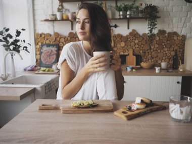 Genç bir kadın bilgisayarın başında oturmuş telefonla konuşuyor.
