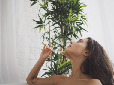 Genç kadın evde banyo yapar, banyo yapar, banyoda yıkanır. Rahatlama