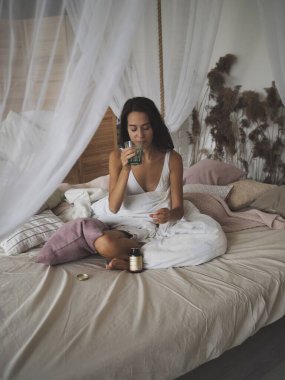 Genç kadın vitamin ve takviye maddeleri içiyor.