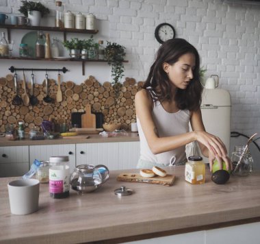 Genç vejetaryen kadın kendine lezzetli ve sağlıklı bir kahvaltı hazırlıyor.