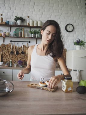Genç vejetaryen kadın kendine lezzetli ve sağlıklı bir kahvaltı hazırlıyor.