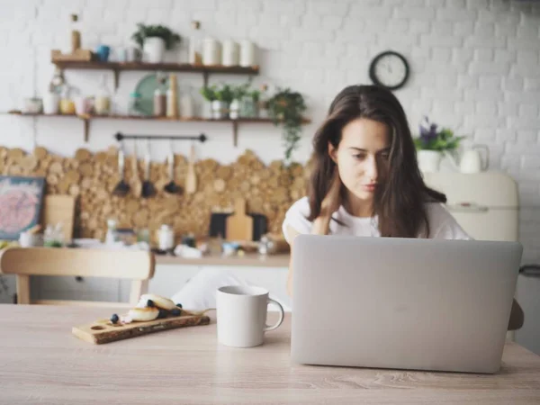 Genç bir kadın video aracılığıyla iletişim kuruyor, evdeki bilgisayarla uzaktan çalışıyor.