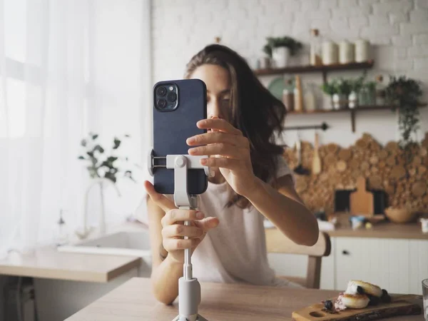 young woman communicates on the phone via video call, works remotely on the computer at home