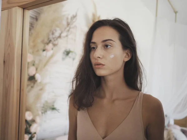 Genç bir kadın bilgisayarın başında oturmuş telefonla konuşuyor.