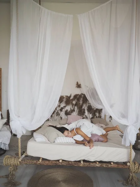 Evde yatakta uyuyan genç kadın.