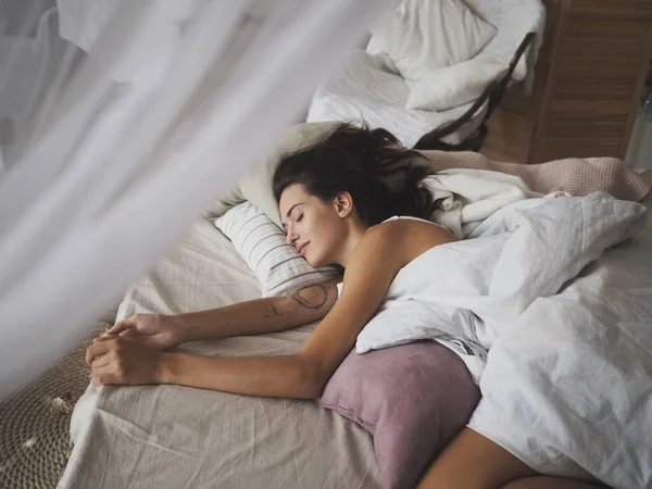 Evde yatakta uyuyan genç kadın.