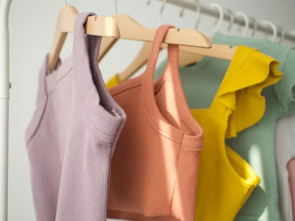 Çocukların tırtıklı kıyafetleri askılara asılı.