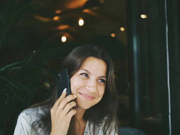 young woman uses the phone in a cafe. taking pictures of food and talking on the phone