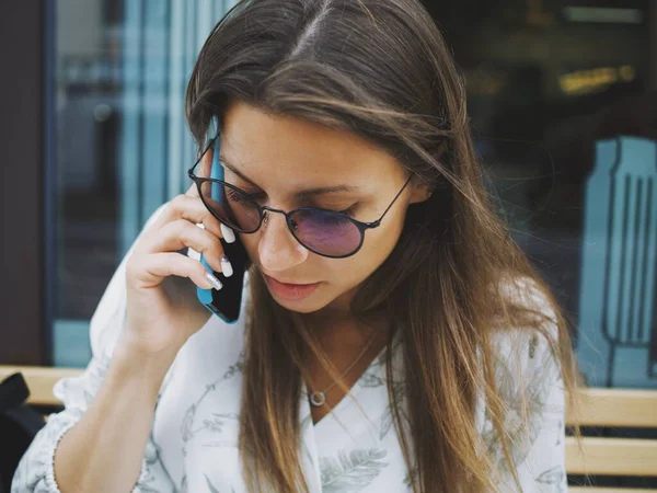 young woman uses the phone in a cafe. taking pictures of food and talking on the phone