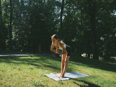 Parkta yoga, pozlar, assanalar, esneme ve esneklik, yoga kıyafetleri.