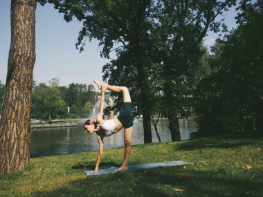 Parkta yoga, pozlar, assanalar, esneme ve esneklik, yoga kıyafetleri.