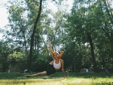 Parkta yoga, pozlar, assanalar, esneme ve esneklik, yoga kıyafetleri.