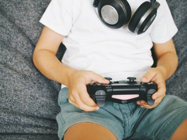 Çocuklar TV 'de bilgisayar oyunu joystick konsolu oynuyorlar