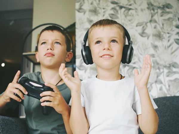 Çocuklar TV 'de bilgisayar oyunu joystick konsolu oynuyorlar