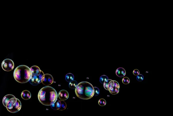 Såpbubblor på svart — Stockfoto