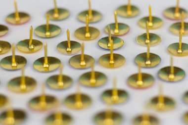 Beyaz arkaplanda küçük raptiyeler izole edildi