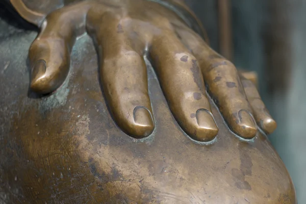 metal hand of an old bronze statue laying