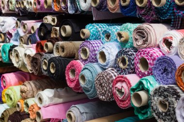 fabric rolls at market stall - textile industry background clipart