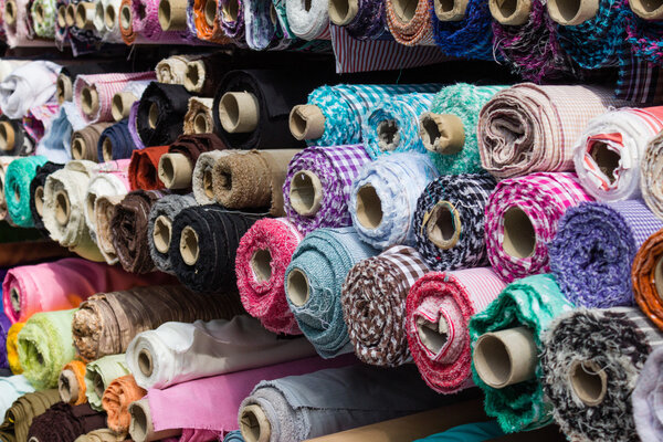 fabric rolls at market stall - textile industry background