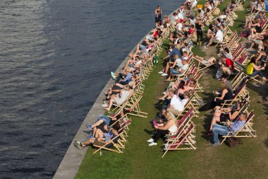 İnsanlar plaj sandalyeleri riverside, rahatlatıcı