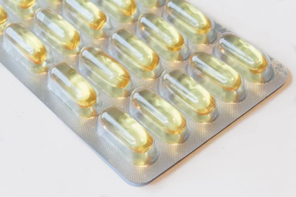Macro de naranja píldoras vitamínicas cápsulas sobre fondo blanco — Foto de Stock