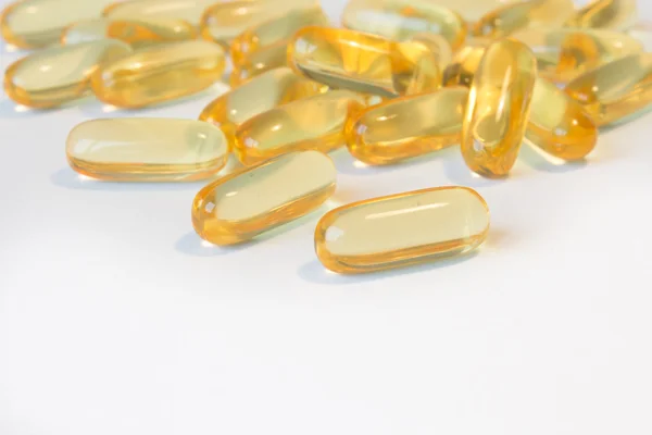 Macro van Oranje vitamine pillen capsules op witte achtergrond — Stockfoto