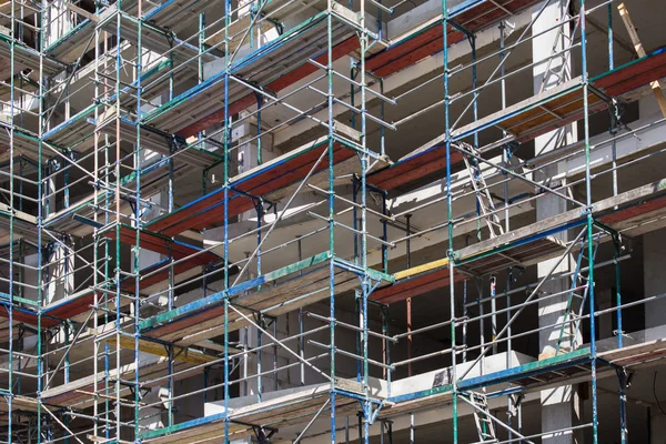 Fachada del edificio con andamios - sitio de construcción —  Fotos de Stock