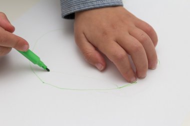 boş kağıt üzerine kalem tutan çocuk. Çocuk boş kağıt üzerinde çizer