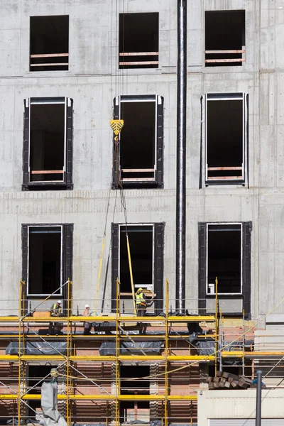 Trabajadores de la construcción en andamios - edificio fachada constructi —  Fotos de Stock