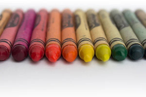 old wax crayons on white paper - vintage color pencils closeup