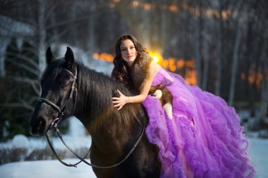 siyah bir at ile güzel bir genç kadın