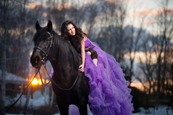 Belle jeune femme avec un cheval noir — Photo