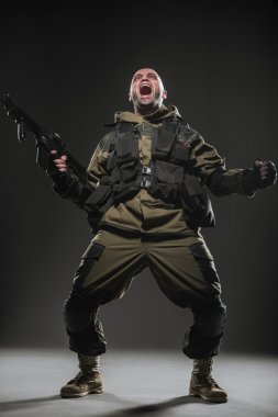 soldier man hold Machine gun on a  dark background clipart
