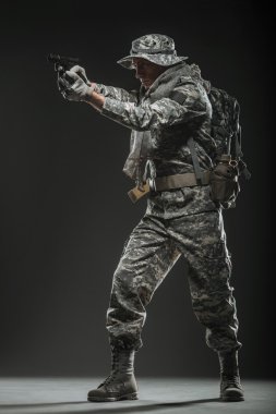 Special forces soldier man with gun on a  dark background clipart