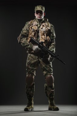 Asker adam tutun makineli tüfek karanlık bir arka plan üzerinde