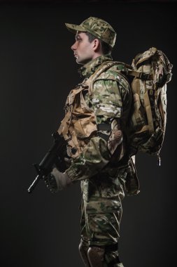 Asker adam tutun makineli tüfek karanlık bir arka plan üzerinde