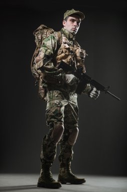 Asker adam tutun makineli tüfek karanlık bir arka plan üzerinde