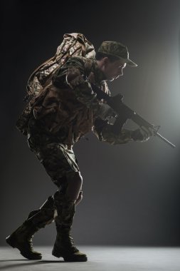 Asker adam tutun makineli tüfek karanlık bir arka plan üzerinde