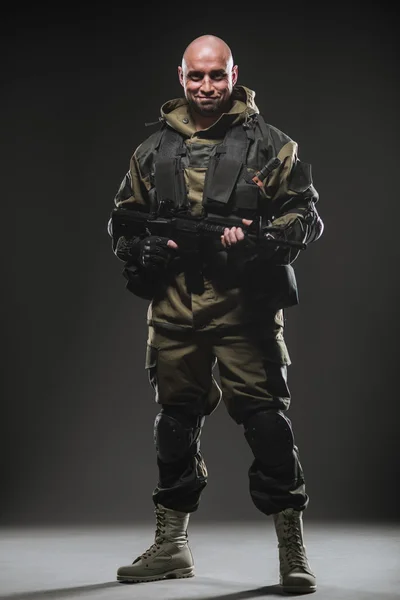 Στρατιώτης άνθρωπος κρατήστε πολυβόλο σε σκούρο φόντο — Φωτογραφία Αρχείου