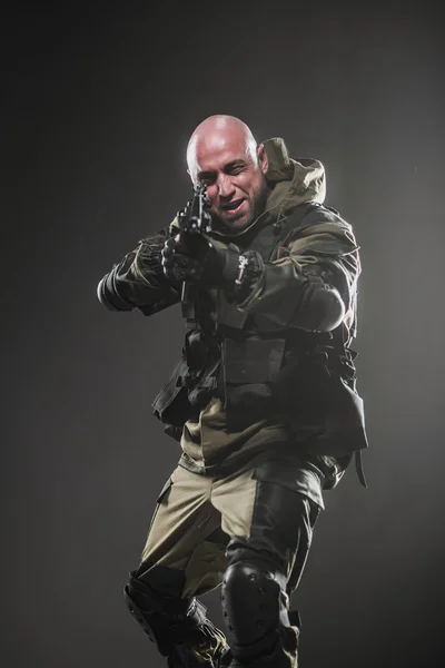 Soldat mannen hålla kulspruta på en mörk bakgrund — Stockfoto