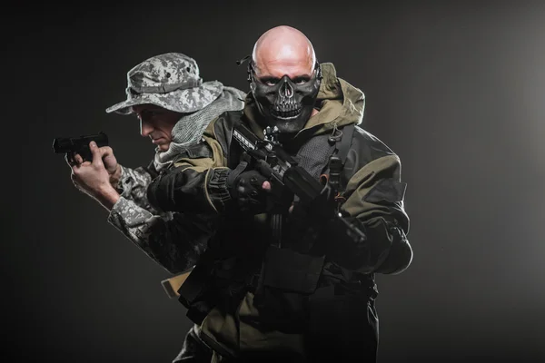 Солдаты спецназа с пулеметом на тёмном фоне — стоковое фото