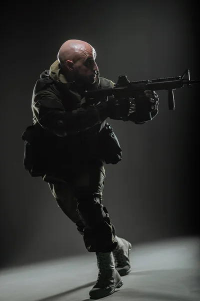 Soldat homme tenir mitrailleuse sur un fond sombre — Photo
